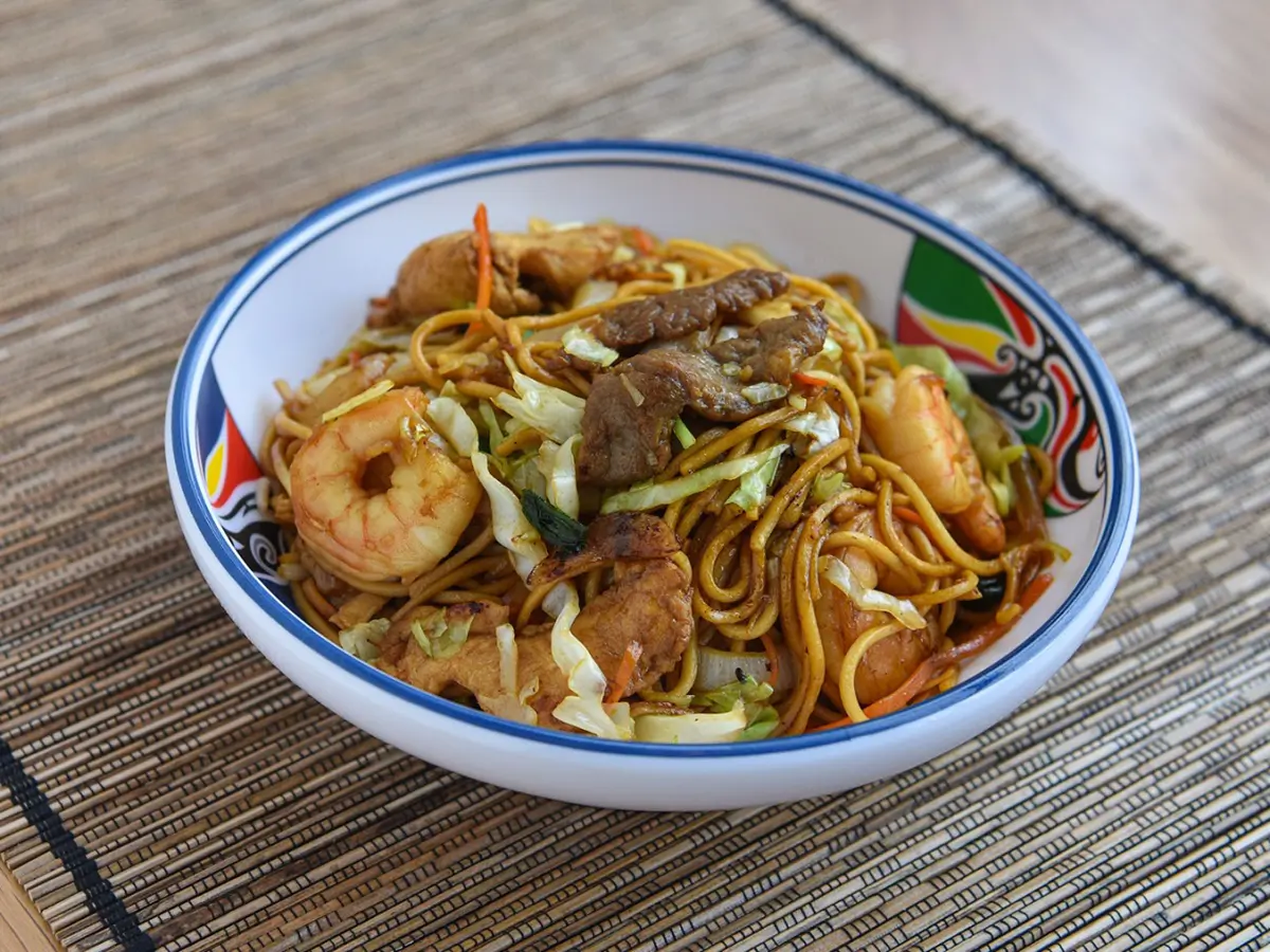 Seafood and Mixed Meat Fried Noodles are noodles stir - fried with shrimp, pieces of meat, cabbage, carrots, and other vegetables for a hearty dish